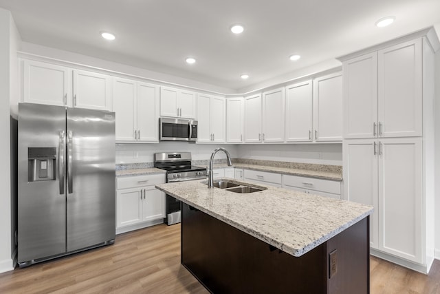 kitchen with white cabinets, sink, stainless steel appliances, and light hardwood / wood-style flooring