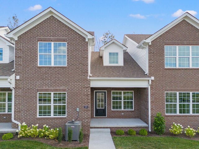 view of front of home with central AC unit and a patio