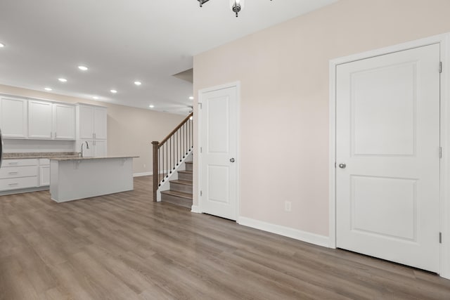 unfurnished living room featuring sink and light hardwood / wood-style floors