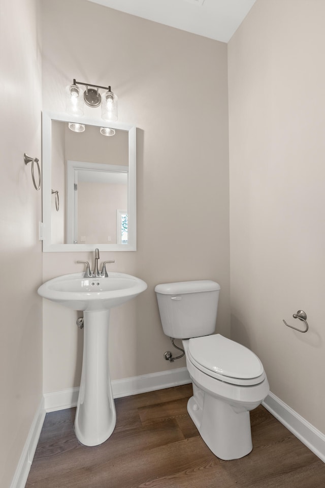 bathroom featuring sink, toilet, and wood-type flooring