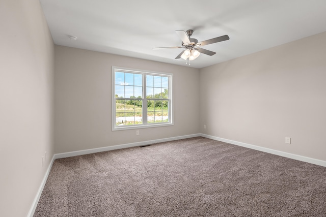 carpeted spare room featuring ceiling fan