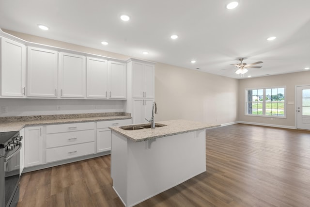 kitchen with white cabinets, a center island with sink, stainless steel electric range oven, and sink