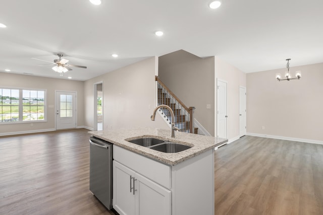 kitchen with hanging light fixtures, dishwasher, light stone counters, white cabinets, and sink