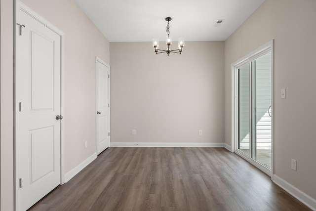 unfurnished dining area featuring hardwood / wood-style floors and a chandelier