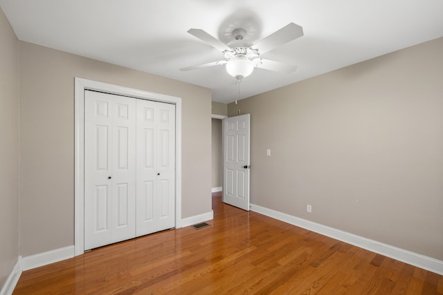 unfurnished bedroom featuring a closet, ceiling fan, and hardwood / wood-style flooring