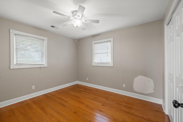 unfurnished bedroom featuring ceiling fan, wood-type flooring, and a closet