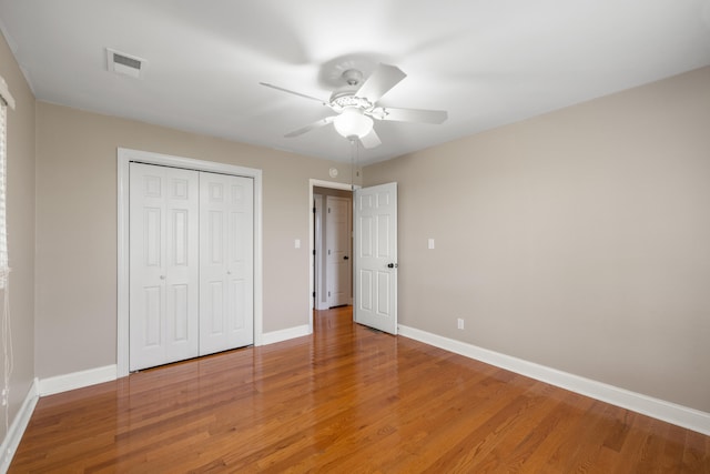 unfurnished bedroom featuring a closet, ceiling fan, and hardwood / wood-style flooring