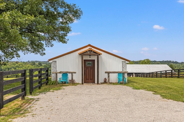 view of outdoor structure with a rural view and a lawn