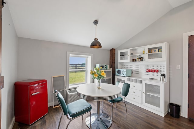 dining area with vaulted ceiling and dark wood-type flooring