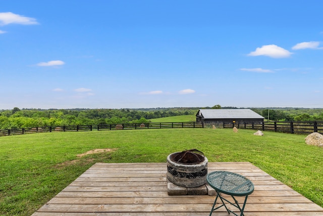 deck featuring a rural view, a fire pit, and a yard