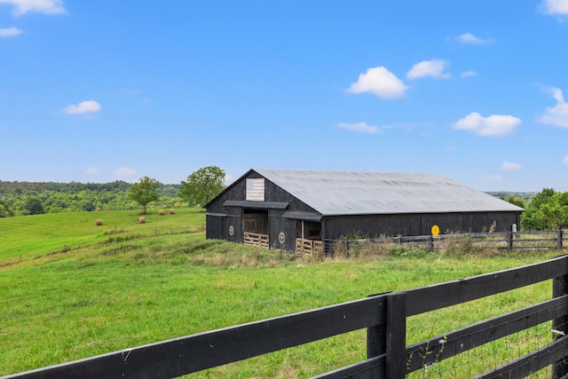 view of front of house with a rural view, an outbuilding, and a front lawn