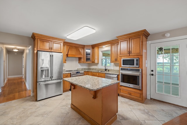 kitchen featuring stainless steel appliances, light hardwood / wood-style flooring, sink, a center island, and custom exhaust hood