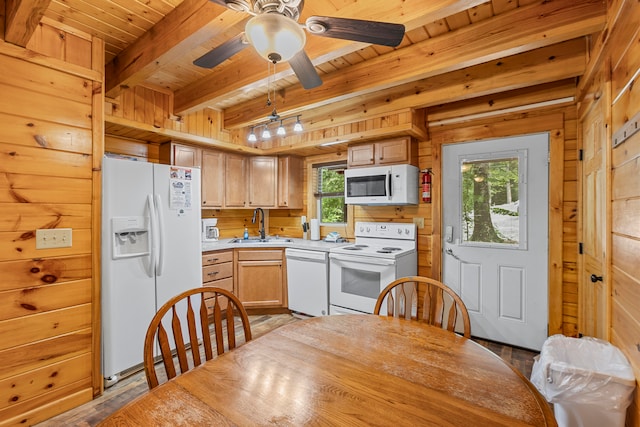 kitchen with white appliances, light brown cabinets, plenty of natural light, and beam ceiling