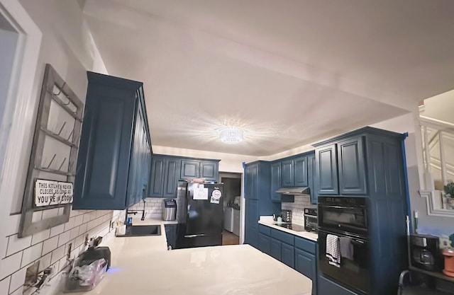 kitchen with sink, tasteful backsplash, kitchen peninsula, blue cabinetry, and black appliances