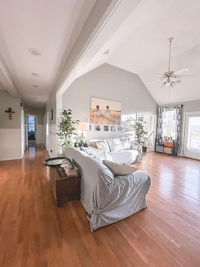 living room with ceiling fan, hardwood / wood-style flooring, and lofted ceiling