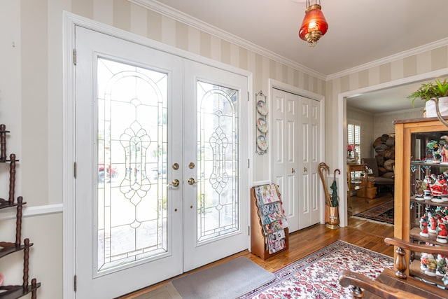 foyer with ornamental molding, hardwood / wood-style flooring, and french doors