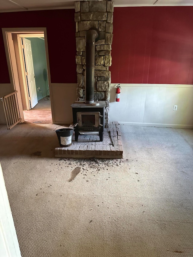 carpeted living room with a wood stove