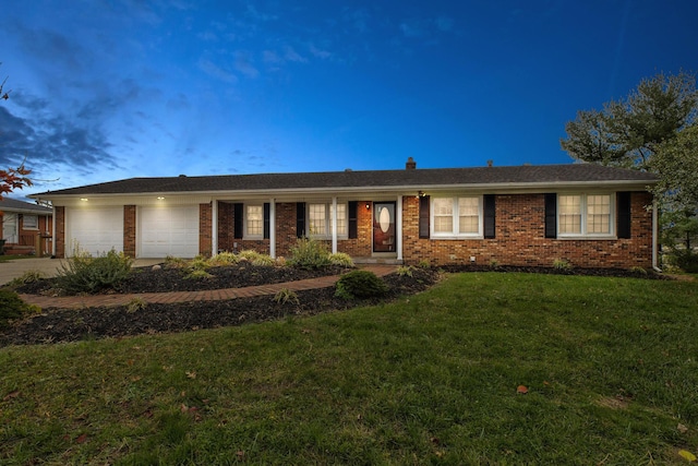 ranch-style house featuring a lawn and a garage