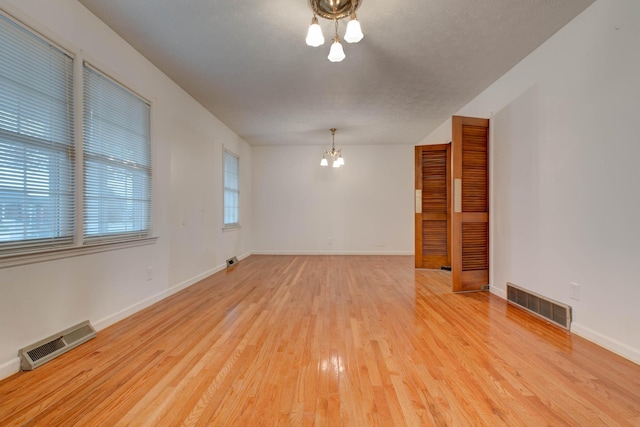 unfurnished room with hardwood / wood-style flooring and a textured ceiling