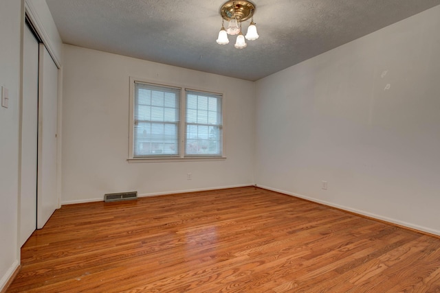 unfurnished bedroom with a closet, light hardwood / wood-style flooring, and a textured ceiling