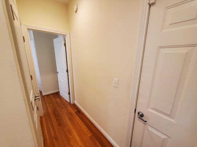 hall featuring baseboards and wood finished floors