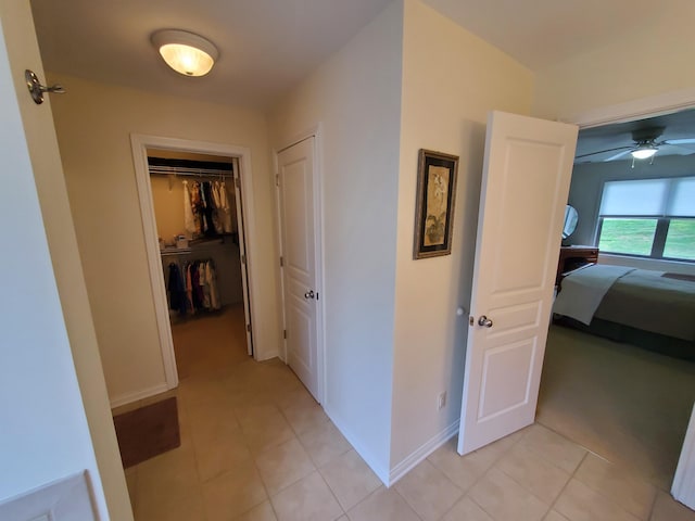 hallway with baseboards and light tile patterned floors