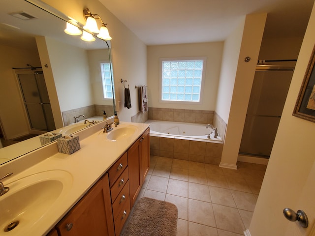 full bathroom with a jetted tub, visible vents, a sink, and tile patterned floors