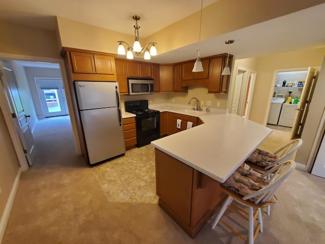 kitchen with a breakfast bar area, stainless steel appliances, light countertops, pendant lighting, and a sink