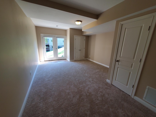 empty room with baseboards, visible vents, and light colored carpet