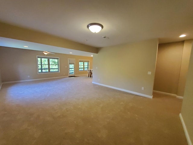 unfurnished room with light carpet, recessed lighting, and baseboards