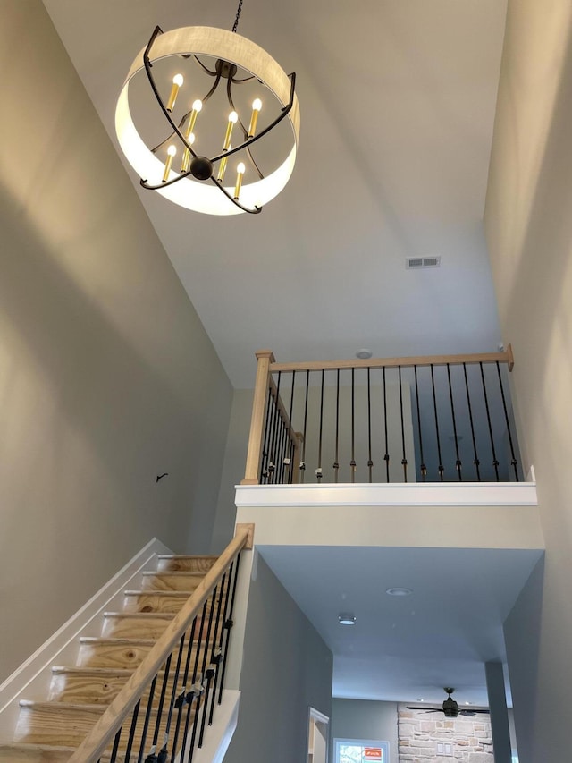 stairs with a towering ceiling and a chandelier