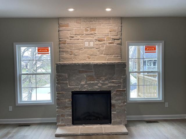 interior details featuring hardwood / wood-style flooring and a stone fireplace