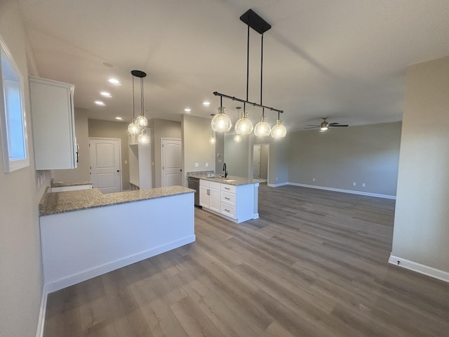 kitchen featuring white cabinetry, dishwasher, sink, and decorative light fixtures