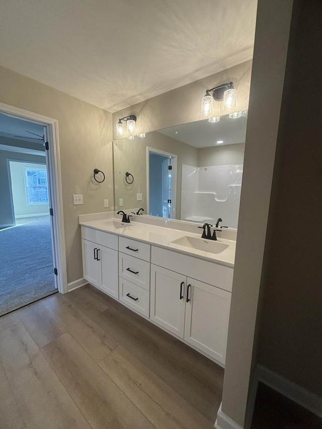 bathroom with vanity, hardwood / wood-style floors, and a shower