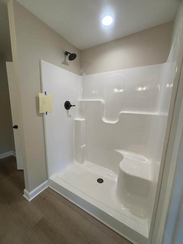 bathroom featuring walk in shower and wood-type flooring