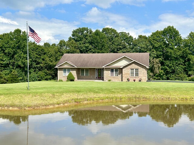 ranch-style house featuring a front yard and a water view