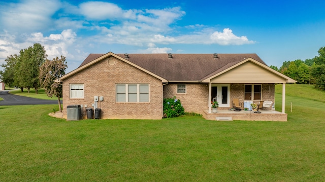 back of house featuring central AC, a patio area, and a lawn