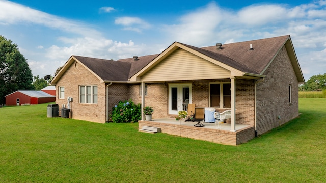 back of house with central air condition unit, a patio area, french doors, and a lawn