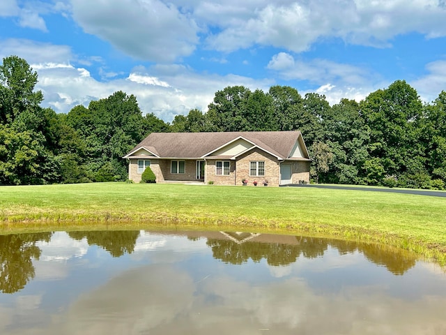 view of front of home with a front lawn, a water view, and a garage