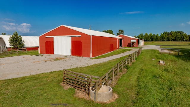 view of outbuilding with a rural view and a yard