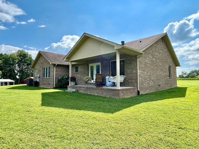 rear view of property with a patio and a yard