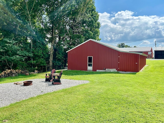 view of outdoor structure featuring a fire pit and a lawn