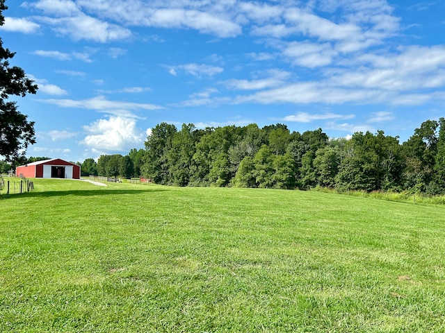 view of yard with a rural view and an outdoor structure