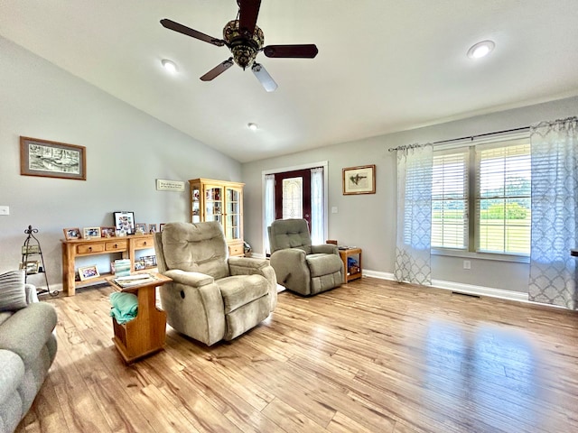 living room with ceiling fan, vaulted ceiling, and light hardwood / wood-style floors