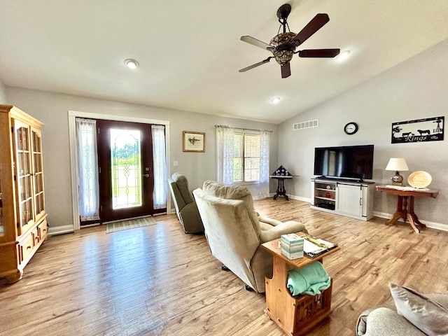 living room with ceiling fan, lofted ceiling, and light hardwood / wood-style floors