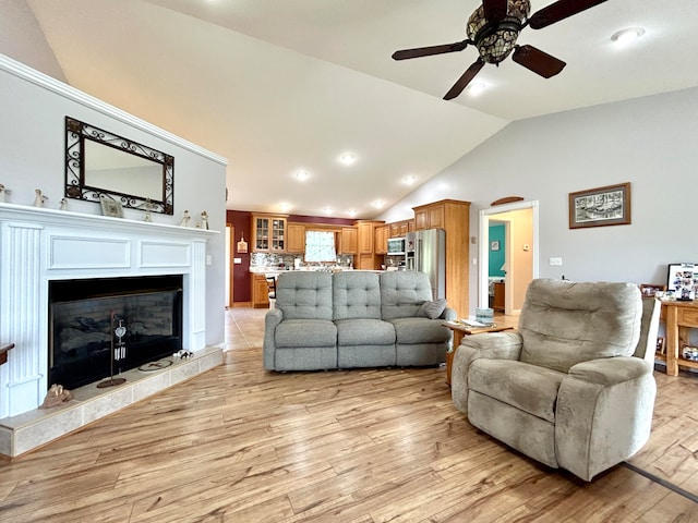 living room with ceiling fan, high vaulted ceiling, and light hardwood / wood-style floors