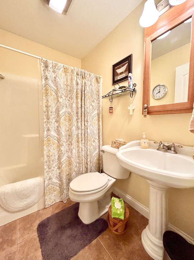 bathroom featuring tile patterned floors, toilet, and shower / tub combo