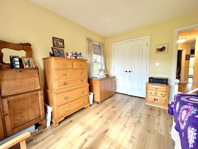 bedroom with light wood-type flooring and a closet