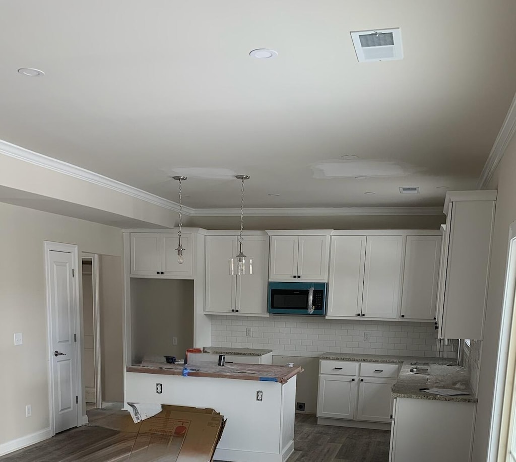 kitchen with pendant lighting, white cabinets, dark hardwood / wood-style flooring, sink, and backsplash