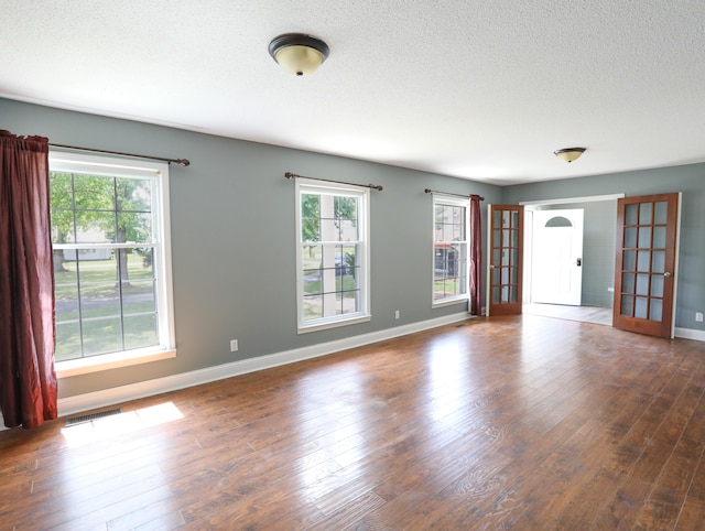 empty room featuring hardwood / wood-style flooring and a textured ceiling